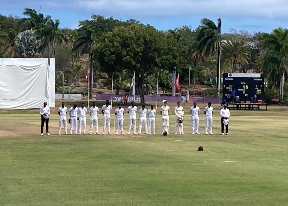 England batters Dan Lawrence and Ben Foakes stand with Cricket West Indies President’s XI players during a moment of silence for Shane Warne (PA Wire)