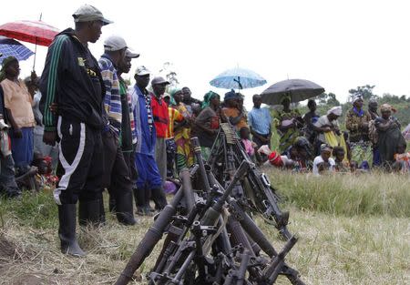 Militants from the Democratic Forces for the Liberation of Rwanda (FDLR) stand near a pile of weapons after their surrender in Kateku, a small town in eastern region of the Democratic Republic of Congo (DRC), May 30, 2014. REUTERS/Kenny Katombe