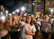 <p>Mary Claire Foley, center left, 16, embraces Ariana Skafidas, 16, students at Henry B. Plant High School at Curtis Hixon Park in downtown Tampa, Fla., Monday, Feb. 19, 2018, as they raise their lights during a vigil to honor victims of Wednesday’s shooting at Marjory Stoneman Douglas High School in Parkland, Fla. (Photo: Dirk Shadd/Tampa Bay Times via AP) </p>