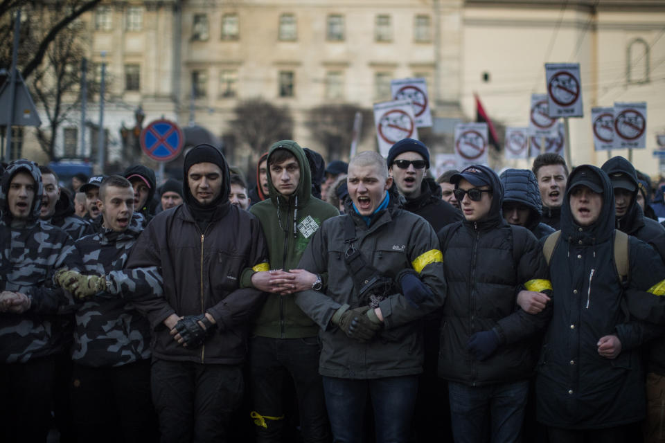 Members of right-wing National Corps march toward an election campaign rally of Petro Poroshenko, President of Ukraine and candidate for 2019 elections, in Lviv, Ukraine, Thursday, March 28, 2019. Presidential elections will be held in Ukraine on 31 March 2019. (AP Photo/Emilio Morenatti)