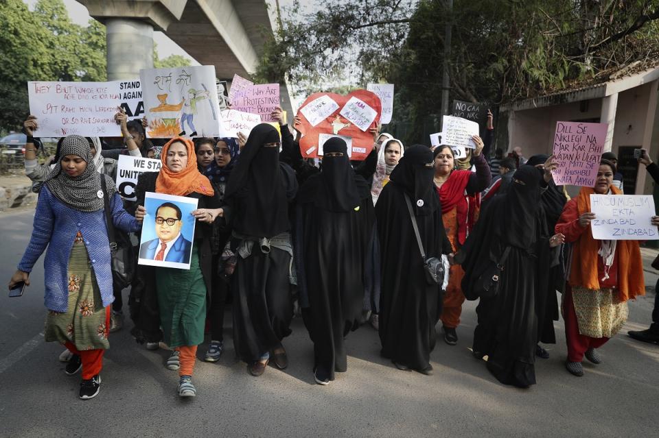 A students holds a photograph of Bhima Rao Ambedkar as Indian students of the Jamia Millia Islamia University march during a protest, in New Delhi, India, Wednesday, Dec. 18, 2019. (AP Photo/Altaf Qadri)