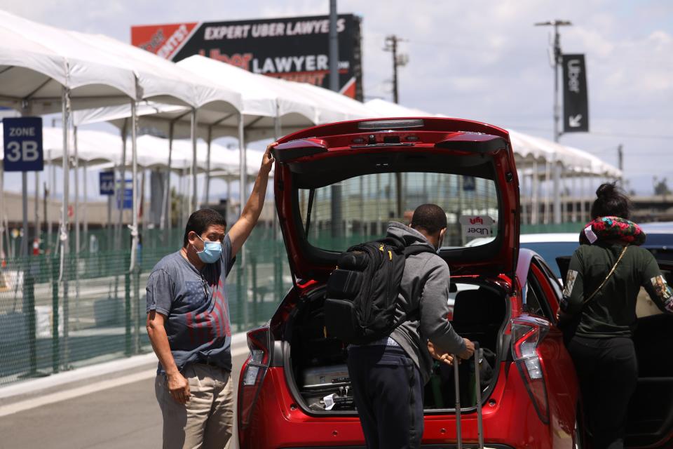 LOS ANGELES, CA - MAY 19, 2020 - - An Uber driver picks up passengers a day after Uber Technologies, Inc. cut 3,000 jobs as their business has been gutted by the coronavirus at Los Angeles International Airport on May 19, 2020. (Genaro Molina / Los Angeles Times via Getty Images)