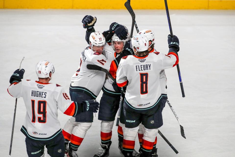Coachella Valley Firebirds celebrate the overtime goal by forward Andrew Poturalski (22), center, against the Abbotsford Canucks at Acrisure Arena in Palm Desert, Calif., on Wed., Dec. 13, 2023.