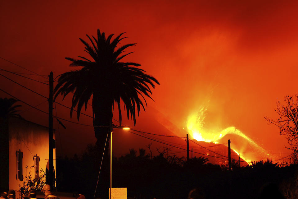 A volcano continues to spew out lava on the Canary island of La Palma, Spain in the early hours of Sunday, Oct. 10, 2021. A new river of lava has belched out from the La Palma volcano, spreading more destruction on the Atlantic Ocean island where molten rock streams have already engulfed over 1,000 buildings. The partial collapse of the volcanic cone overnight sent a new lava stream Saturday heading toward the western shore of the island. (AP Photo/Daniel Roca)