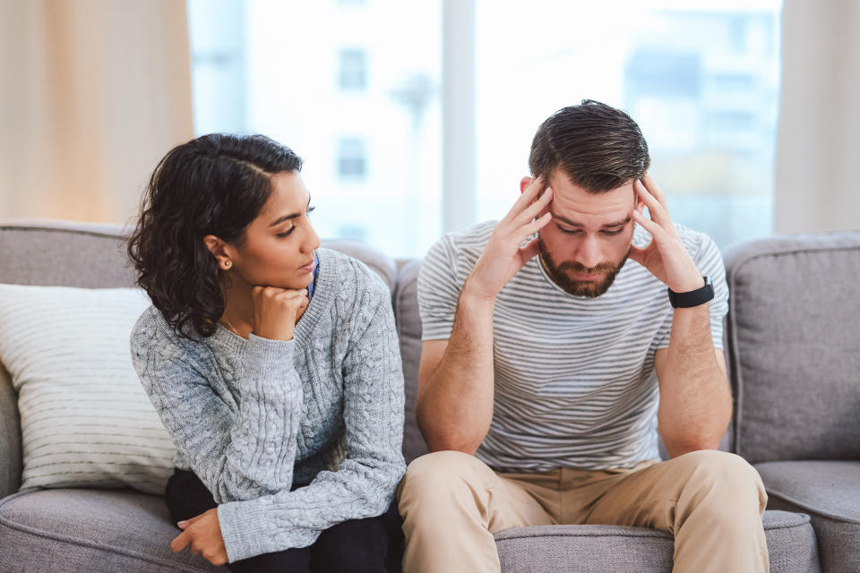 Couple sitting and arguing while they're on the couch