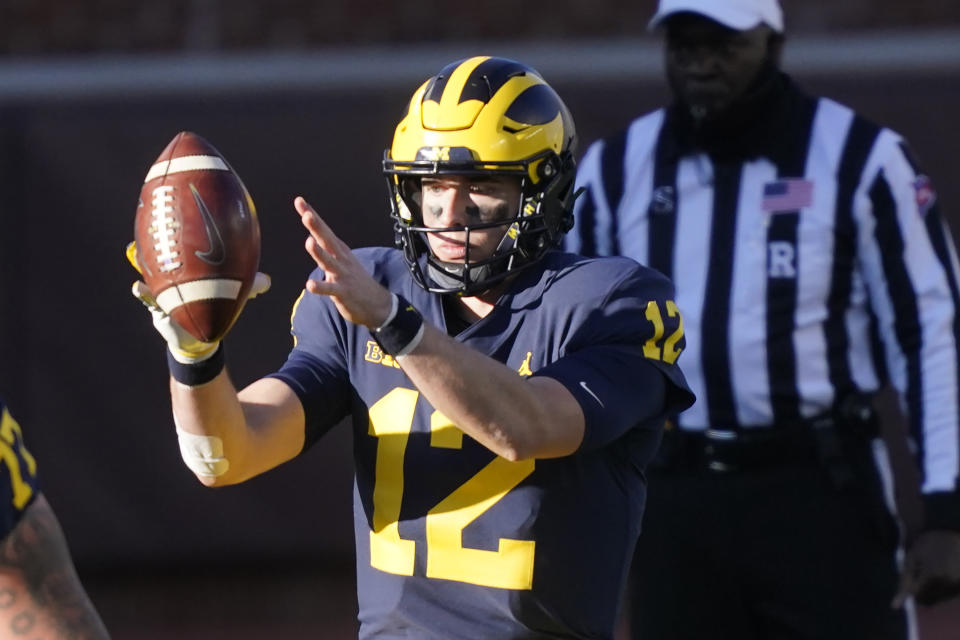 Michigan quarterback Cade McNamara takes the snap during the second half of an NCAA college football game against Penn State, Saturday, Nov. 28, 2020, in Ann Arbor, Mich. (AP Photo/Carlos Osorio)