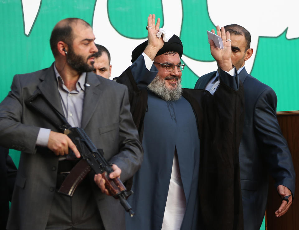 FILE - In this Monday, Sept 17, 2012 file photo, Hezbollah leader Sheik Hassan Nasrallah, center, escorted by his bodyguards, waves to a crowd of tens of thousands of supporters during a rally denouncing an anti-Islam film that has provoked a week of unrest in Muslim countries worldwide, in the southern suburb of Beirut, Lebanon. The Shiite group has sent hundreds of its fighters into Syria to shore up President Bashar Assad’s overstretched troops, helping them gain ground around the capital, Damascus, and near the Lebanese border. But with its own casualties mounting in a civil war that activists say has killed more than 150,000 people in three years, officials say Hezbollah has turned to a variety of new tactics - including complicated commando operations - to hunt down rebels and opposition commanders. (AP Photo/Hussein Malla, File)