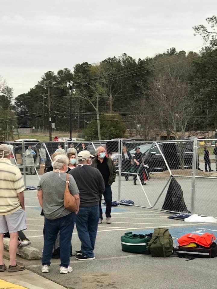 A barricade fence separates passengers from the Grand Princess cruise ship under federal quarantine at Dobbins Air Reserve Base in Georgia.