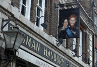 A sign showing Britain's Prince Harry and his wife Meghan, hangs outside the Duke of Sussex pub near Waterloo station, London, Tuesday March 9, 2021. Prince Harry and Meghan's explosive TV interview has divided people around the world, rocking an institution that is struggling to modernize with claims of racism and callousness toward a woman struggling with suicidal thoughts. (AP Photo/Tony Hicks)