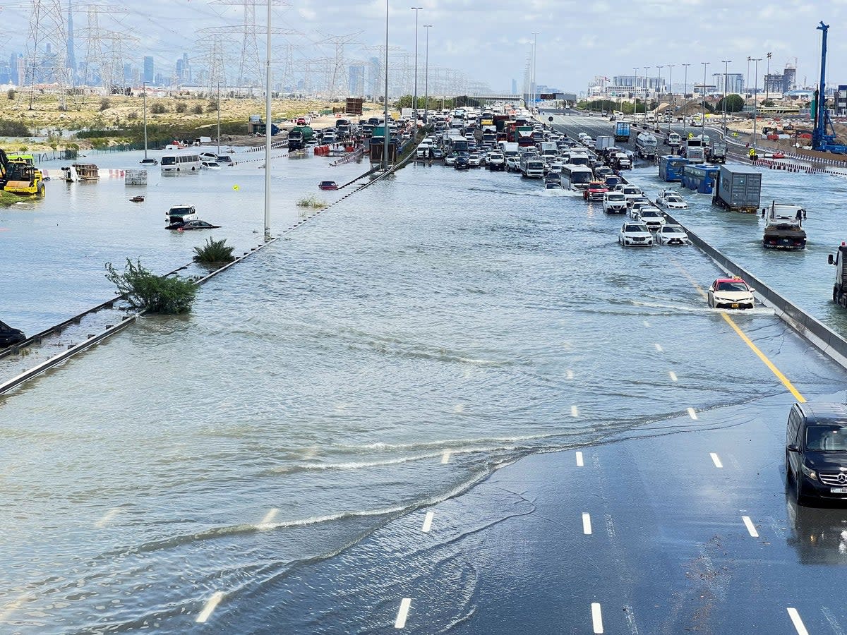 Vehicles brought to a standstill by a severely flooded road in Dubai (REUTERS)