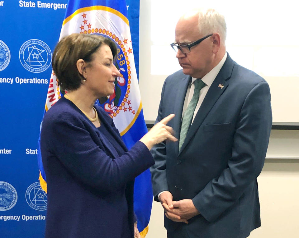 FILE - In this March 15, 2019 file photo, Minnesota Gov. Tim Walz, right, and Sen. Amy Klobuchar, D-Minn., talk before a briefing from state and federal emergency managers who are gearing up for a flood threat caused by some of the heaviest snow in years in St. Paul, Minn. Democratic presidential candidate Klobuchar is proposing an infrastructure plan she says will provide $1 trillion to fix roads and bridges, protect against flooding and rebuild schools and other projects. The plan announced Thursday is the first policy proposal from the Minnesota senator since she joined the 2020 race. (AP Photo/Steve Karnowski, File)