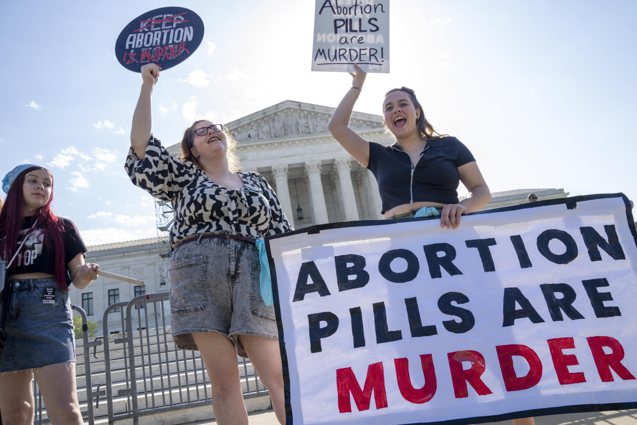 Staff with the group, Progressive Anti-Abortion Uprising, Kristin Turner, of San Francisco, left, Lauren Handy, of Washington, and Caroline Smith, of Washington, right, demonstrate against abortion pills outside of the Supreme Court, Friday, April 21, 2023, ahead of an abortion pill decision by the court in Washington. (AP Photo/Jacquelyn Martin)