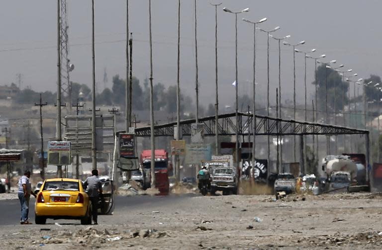 Iraqis get out of a vehicle at a checkpoint staffed by Islamic militants in Mosul on June 16, 2014