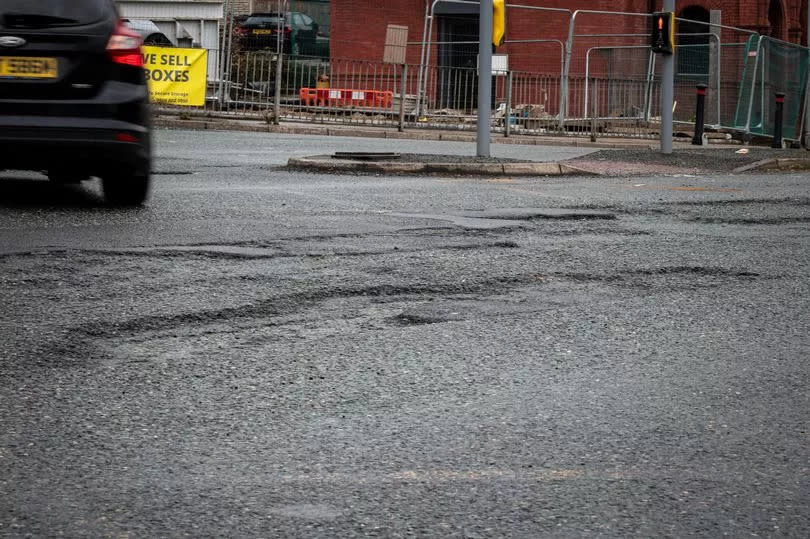 Some of the twenty potholes, cracks, and craters at the junction of Church Lane and Bury New Road.