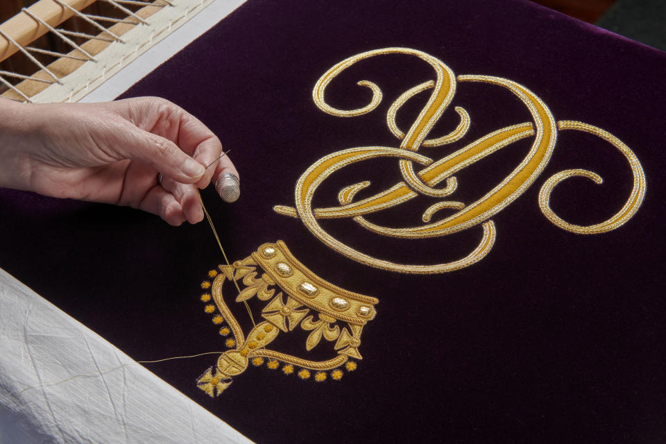 Undated handout photo issued by Buckingham Palace of a member of the Royal School of Needlework hand embroidering the Queen Consort's cypher onto her Robe of Estate, which she will wear at the coronation on May 6. Issue date: Saturday April 29, 2023. (Royal School of Needlework / PA Wire)