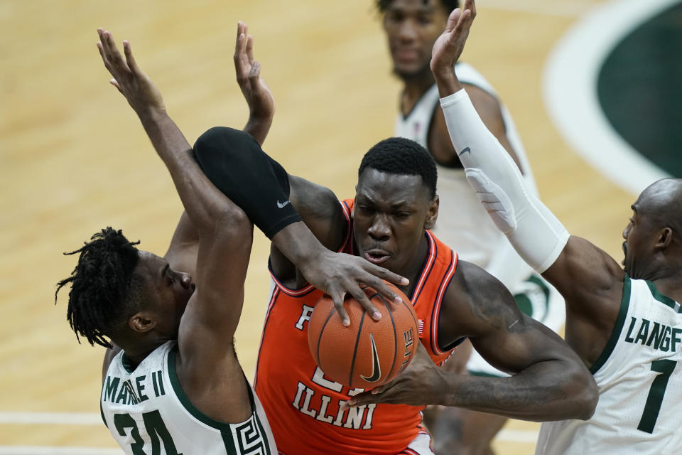 Illinois center Kofi Cockburn (21) is defended by Michigan State forward Julius Marble II (34) and guard Joshua Langford (1) during the first half of an NCAA college basketball game, Tuesday, Feb. 23, 2021, in East Lansing, Mich. (AP Photo/Carlos Osorio)