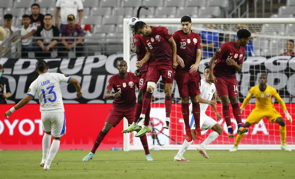 Qatar players jump for the ball