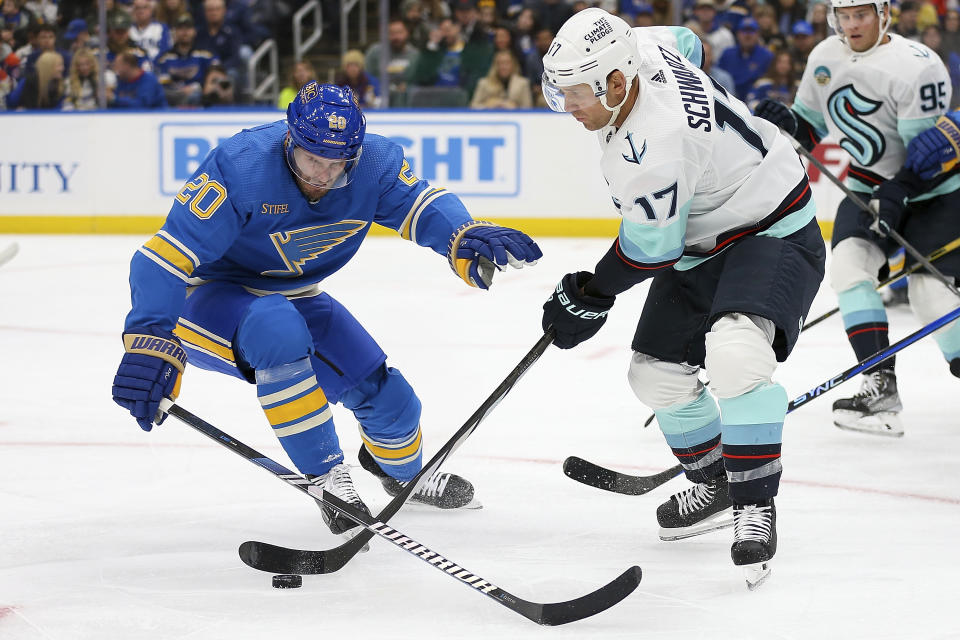 Seattle Kraken's Jaden Schwartz (17) controls the puck while under pressure from St. Louis Blues' Brandon Saad (20) during the first period of an NHL hockey game Saturday, Oct. 14, 2023, in St. Louis. (AP Photo/Scott Kane)