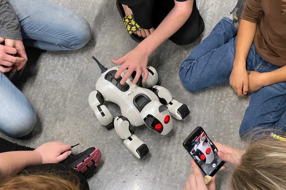 Students at the Hsu Innovation Institute  crowd around a dog-shaped robot during a recent Open Robotics Day at the facility in Fort Walton Beach.