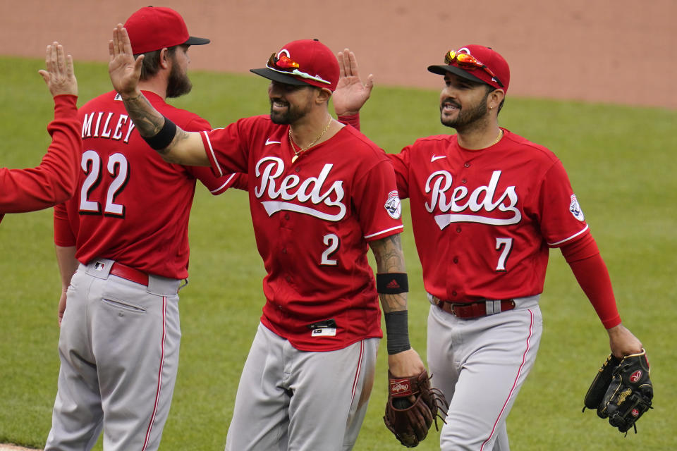 Cincinnati Reds' Eugenio Suarez (7) celebrates as he walks off the field with Nick Castellanos (2) after getting the final out of a baseball game against the Pittsburgh Pirates in Pittsburgh, Wednesday, May 12, 2021. The Reds won 5-1.(AP Photo/Gene J. Puskar)