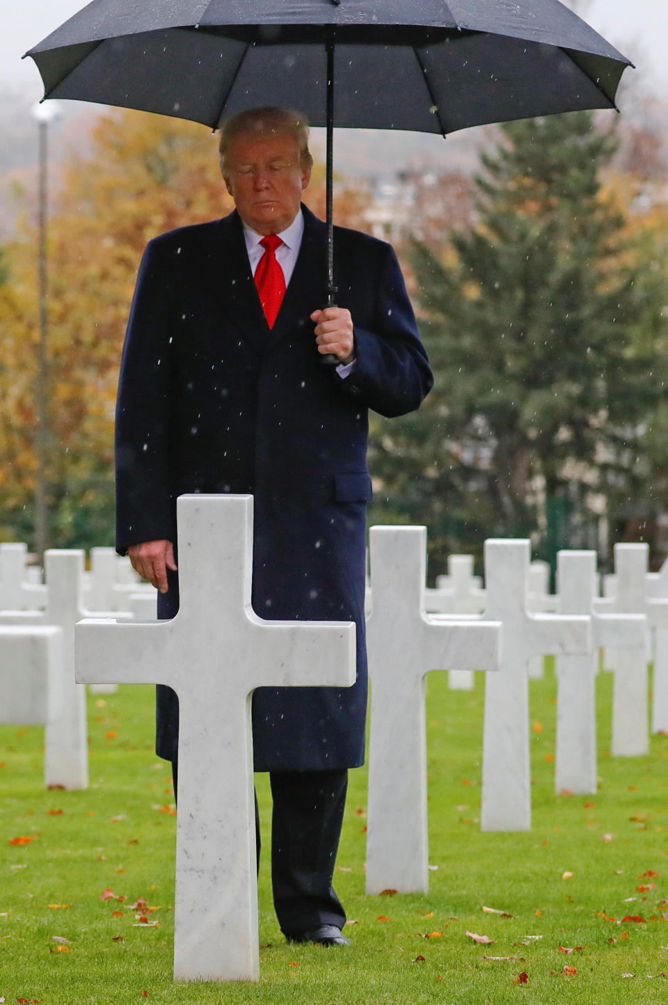 Un día después de cancelar por la lluvia la visita a un cementerio francés donde reposan los restos de soldados estadunidenses muertos en la Primera Guerra Mundial y recibir infinidad de críticas, Donald Trump continuó con el programa de su viaje a Francia y sí acudió, paraguas en mano, a otro campo santo. (Foto: REUTERS/Carlos Barria)