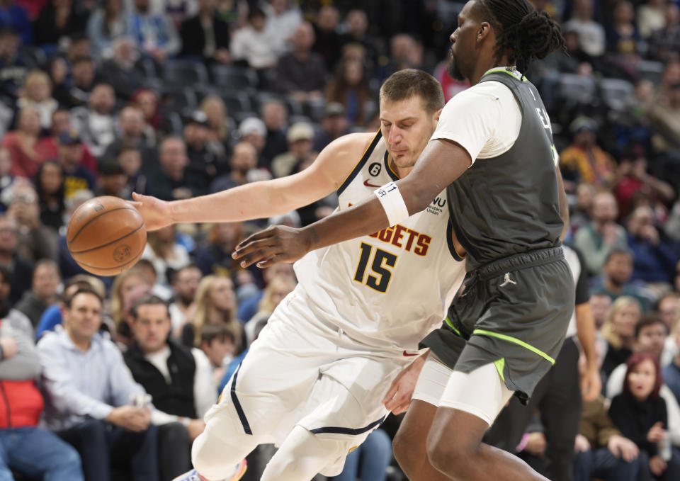 Denver Nuggets center Nikola Jokic, left, drives against Minnesota Timberwolves center Naz Reid during the second half of an NBA basketball game Wednesday, Jan. 18, 2023, in Denver. (AP Photo/David Zalubowski)