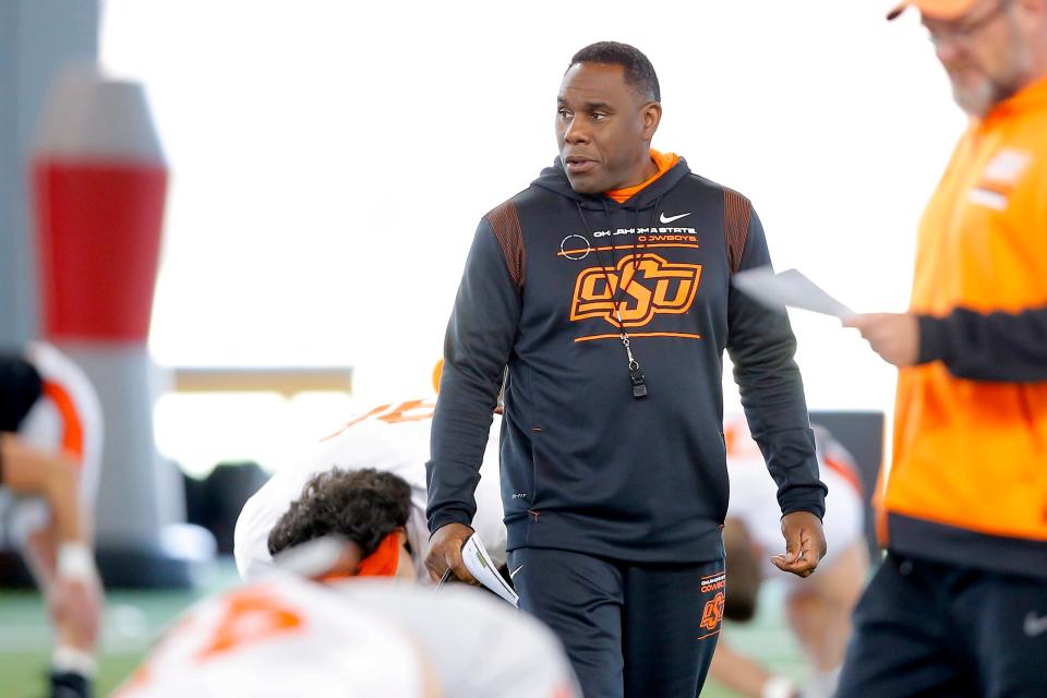 OSU defensive coordinator Derek Mason watches the team stretch before practice on April 11 in Stillwater.