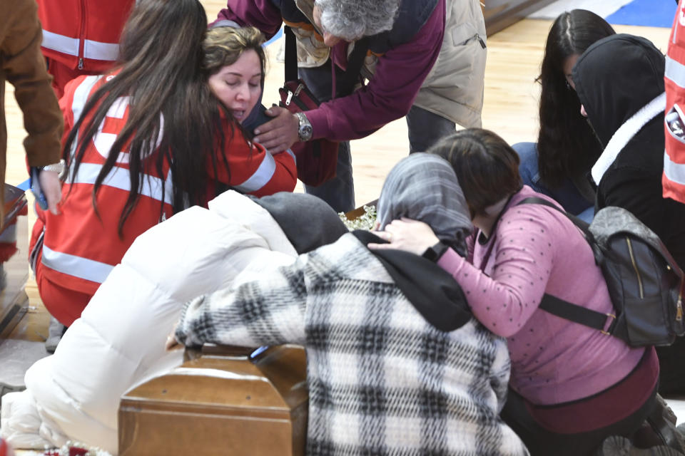 Relatives cry on the coffin of one of the victims of last Sunday's shipwreck at the local sports hall in Crotone, southern Italy, Wednesday, March 1, 2023. At least 67 people, including 14 minors, died when their overcrowded wooden boat slammed into shoals 100 meters (yards) off the shore of Cutro and broke apart early Sunday in rough seas. Eighty people survived, but many more are feared dead since survivors indicated the boat had carried about 170 people when it set off last week from Izmir, Turkey. (AP photo/Giuseppe Pipita)