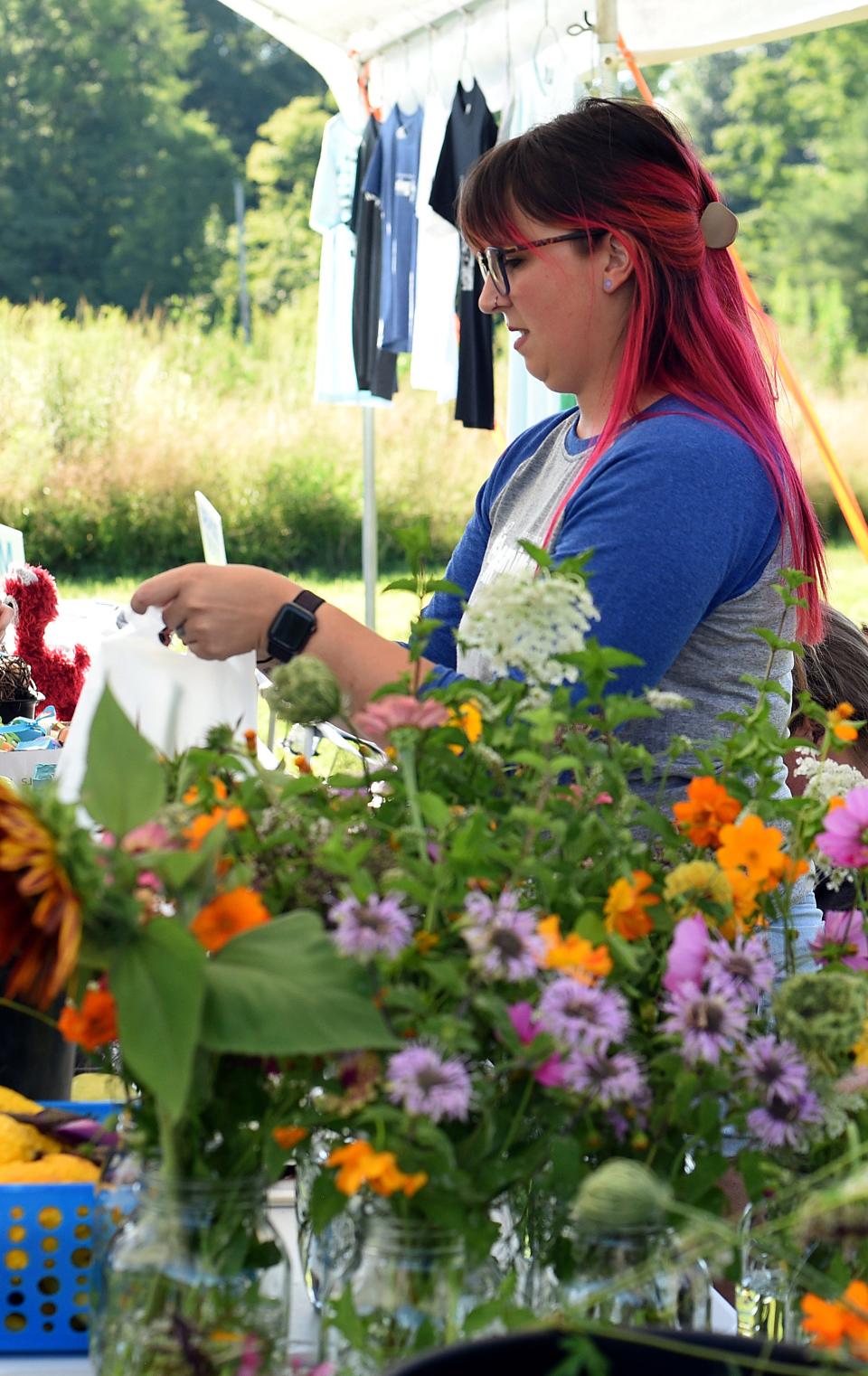 Carmella Bojarzin, a high school teacher at The Learning Spectrum North East school near Johnstown, bags produce grown at the school's affiliated Learning 4 Life Farm during a summer open house on Friday, July 22, 2022. The farm, which provides education and job training for students on the autism spectrum, was celebrating the construction of the new barn for alpacas and expanding of their farm facilities and growing gardens.