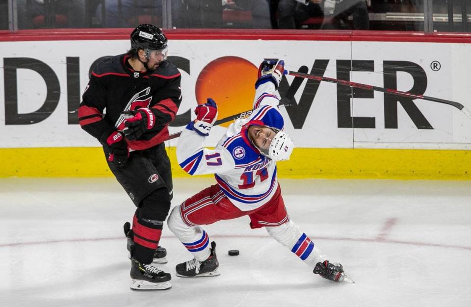 Carolina Hurricanes Brendan Smith (7) checks New York Rangers Kevin Rooney (17) during the second period on Thursday, May 26, 2022 during game five of the Stanley Cup second round at PNC Arena in Raleigh, N.C.