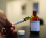 FILE - In this Nov. 6, 2017, file photo, a syringe loaded with a dose of CBD oil is shown in a research laboratory at Colorado State University in Fort Collins, Colo. The Coca-Cola Company says that it's "closely watching" the growth of the use of a non-psychoactive element of cannabis in wellness drinks. (AP Photo/David Zalubowski, File)