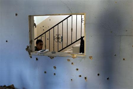 A boy walks past a bullet-riddled wall inside a house where Palestinian Hamas militant Hamza Abu Alhija was killed in the West Bank refugee camp of Jenin March 22, 2014. REUTERS/Mohamad Torokman