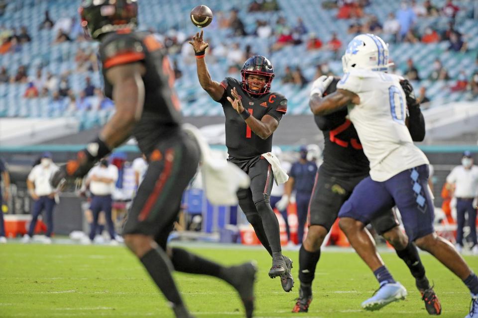 Miami quarterback D'Eriq King (1) throws a touchdown pass to wide receiver Mike Harley (3) during the first half of an during an NCAA college football game against North Carolina at Hard Rock Stadium In Miami Gardens, Fla, Saturday, Dec, 12, 2020. (Al Diaz/Miami Herald via AP)