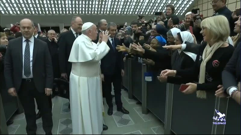 Pope Francis gestures as he jokes to a nun "You bite! I will give you a kiss but you stay calm. Don't bite!", as he arrives for the general audience at the Vatican