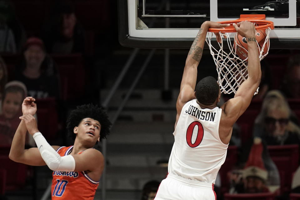 San Diego State forward Keshad Johnson (0) dunks the ball while Boise State guard RayJ Dennis (10) looks on during the second half of an NCAA college basketball game Saturday, Feb 27, 2021, in San Diego. (AP Photo/Gregory Bull)