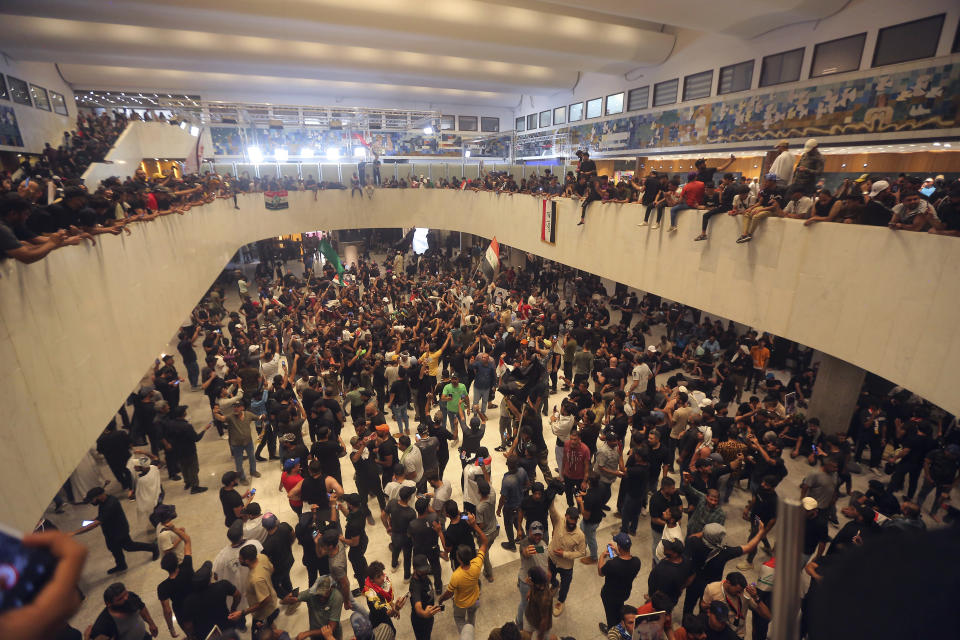 Iraqi protesters fill the Parliament building in Baghdad, Iraq, Saturday, July 30, 2022 as thousands of followers of an influential Shiite cleric breached the building for the second time in a week to protest the government formation efforts lead by Iran-backed groups. Heeding the calls of cleric Muqtada al-Sadr, the demonstrators used ropes to pull down cement barricades leading to the gate of Iraq’s Green Zone. (AP Photo/Anmar Khalil)