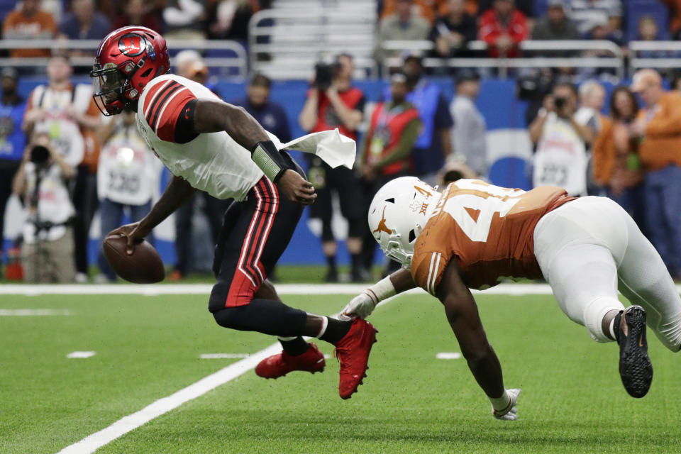 Utah quarterback Tyler Huntley (1) is pressured by Texas linebacker Joseph Ossai (46) during the second half of the Alamo Bowl NCAA college football game in San Antonio, Tuesday, Dec. 31, 2019. (AP Photo/Eric Gay)