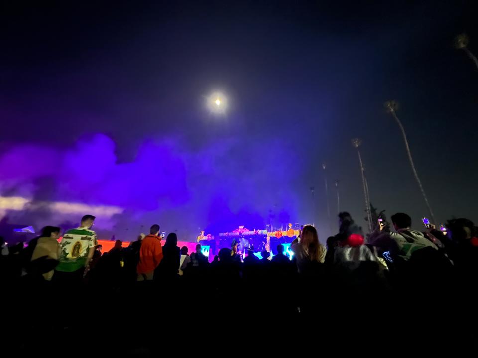 A full moon glows above the crowd watching Colombian band Bomba Estéreo, best known for their song "Ojitos lindos" ("Pretty Eyes") with Bad Bunny, perform at the Día de Los Muertos celebration at the Hollywood Forever Cemetery in Los Angeles on Saturday, Oct. 28, 2023.