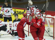 Yevgeni Timkin , centre, Artyom Shvets-Rogovoi, left, and Vladislav Kamenev of Russia celebrate a goal against Darcy Kuemper of Canada during the Ice Hockey World Championship quarterfinal match between Russia and Canada at the Olympic Sports Center in Riga, Latvia, Thursday, June 3, 2021. (AP Photo/Roman Koksarov)