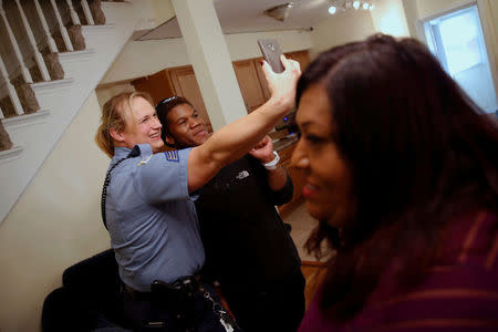 Washington Metropolitan Police Department Sergeant Jessica Hawkins (R), a transgender woman who leads the department's lesbian, gay, bisexual and transgender (LGBT) unit, greets residents at a home where transgender activist Ruby Corado (R) shelters transgender women of color in Washington, U.S. October 10, 2016. REUTERS/Jonathan Ernst