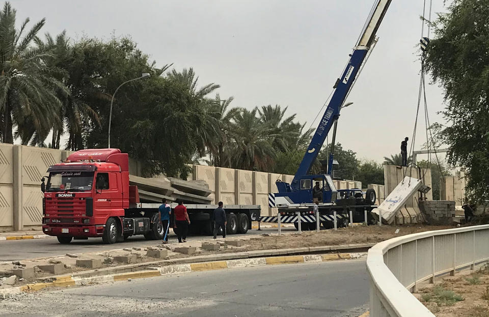 In this Tuesday, May 28, 2019 photo, Iraqi security forces remove concrete blast walls at the Green Zone in Baghdad, Iraq. The Green Zone has been a barometer for tension and conflict in Iraq for nearly two decades. The 4-square mile (10-square kilometer), heavily guarded strip on the Tigris River was known as "Little America" following the 2003 U.S.-led invasion that toppled dictator Saddam Hussein. It then became a hated symbol of the country's inequality, fueling the perception among Iraqis that their government is out of touch. (AP Photo/Ali Abdul Hassan)