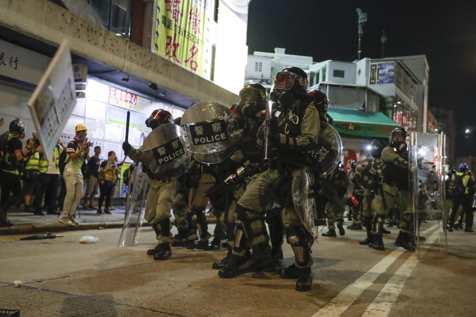 Riot police clash with protesters on the street of Yuen Long, Hong Kong, Monday, Oct. 21, 2019. A evening sit-in at a suburban train station on the three-month anniversary of a violent attack there on protesters by men with suspected organized crime ties. (AP Photo/Mark Schiefelbein)