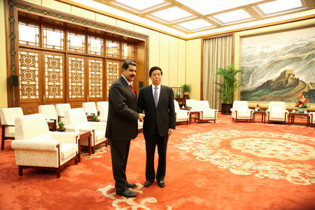 Venezuela's President Nicolas Maduro and China's Li Zhanshu, chairman of the Standing Committee of the National People's Congress (NPC), shake hands during their meeting in Beijing, China September 14, 2018. Miraflores Palace/Handout via REUTERS