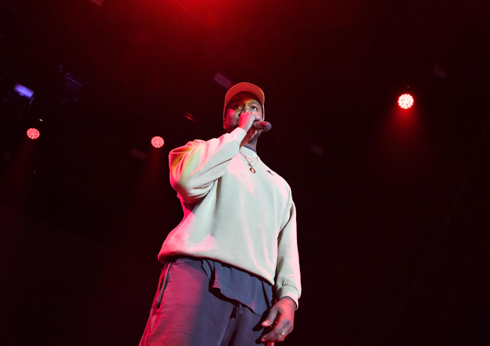 Kanye West wearing grey onstage