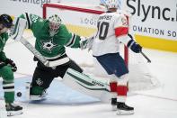 Dallas Stars goaltender Anton Khudobin (35) deflects a shot as Florida Panthers right wing Patric Hornqvist (70) skates past in the second period of an NHL hockey game in Dallas, Saturday, April 10, 2021. (AP Photo/Tony Gutierrez)