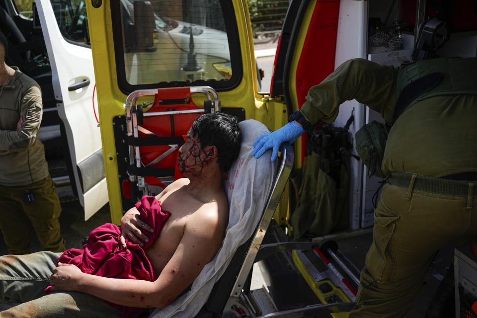 Israeli security forces in Kiryat Shoma, northern Israel, evacuate a wounded Thai man after he was hit by an anti-tank missile fired from Lebanon, in a nearby village on Monday, March 4, 2024. (AP Photo/Ariel Schalit)