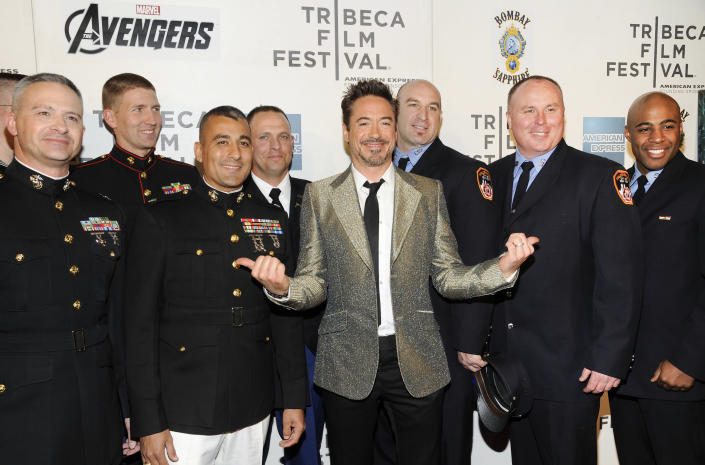 Actor Robert Downey Jr., center, poses with members of the U.S. Military and New York Fire Department before the premiere of "The Avengers" during the 2012 Tribeca Film Festival on Saturday, April 28, 2012 in New York. (AP Photo/Evan Agostini)