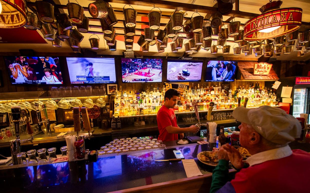 Julian Davila pours a beer as he works at Nick's English Hut during the Indiana University versus Rutgers men's basketball game on Tuesday, Jan. 10, 2024.