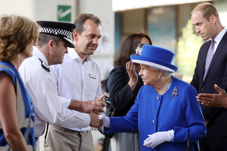 Queen Elizabeth II and Prince William, Duke of Cambridge (R) greet members of emergency services at the scene of the Grenfell Tower fire on June 16, 2017 in London, England. 17 people have been confirmed dead and dozens still missing, after the 24 storey residential Grenfell Tower block in Latimer Road was engulfed in flames in the early hours of June 14. Emergency services will spend a third day searching through the building for bodies. Police have said that some victims may never be identified.