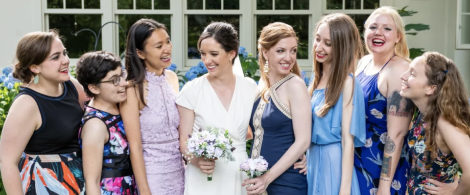 bride with bridesmaids - they are all wearing mismatched wedding dresses. Non-traditional concept.